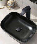 Top view of a Black Rectangle Vessel Sink 18x13 Above Counter Porcelain Ceramic With Faucet And Drain Combo in a modern bathroom.