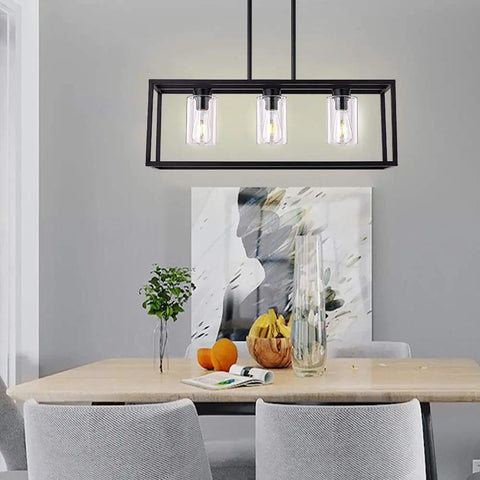 Farmhouse Black Three Light Pendant Fixture With Glass Shades illuminating dining area with artwork and decor