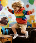 Child jumping near a table with brown 12 Pack Soft Foam Corner Guards For Baby Proofing And Toddler Safety installed.
