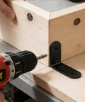 Installing a Beefy Heavy Duty L Shaped Corner Brace on furniture frame with drill in workshop