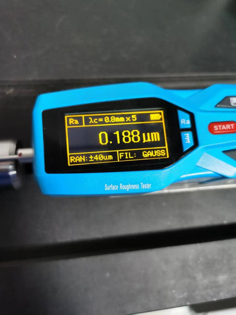 Close-up of a digital surface roughness tester displaying measurement of 0.188 micrometers with blue casing.