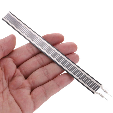FSR408 thin-film pressure sensor strip with interdigitated electrodes and dual leads (hand-held close-up).