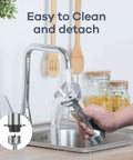Cleaning the Powerful 1000W 5 In 1 Immersion Blender under a kitchen tap, showcasing detachability and stainless steel blades.