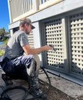 Person using tools wearing self supporting knee pads with removable shin guards, waterproof and washable with built in tool pouches.