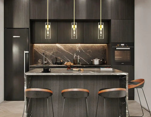Modern Brass Pendant Light Over Kitchen Island With Clear Glass Shade in stylish dark kitchen.