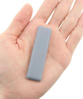 Eight Pack 70x19mm Rectangular PTFE Furniture Sliders With Self Adhesive Backing Heavy Duty Floor Protectors in a hand.