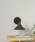 Black Battery Operated Wall Sconce Set Of 2 Industrial Wireless Rechargeable Wall Lights mounted above a shelf with books and plant.