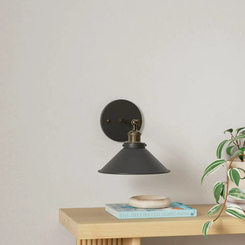 Black Battery Operated Wall Sconce Set Of 2 Industrial Wireless Rechargeable Wall Lights mounted above a shelf with books and plant.