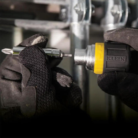 Close-up of hands using Compact Six In One Stubby Ratcheting Screwdriver With Phillips And Slotted Bits Plus One Quarter Inch And Three Sixteenth Inch Nut Drivers Cushioned Grip For Maximum Torque And Comfort Pro Grade Ideal For Tight Spots From Klein Tools.