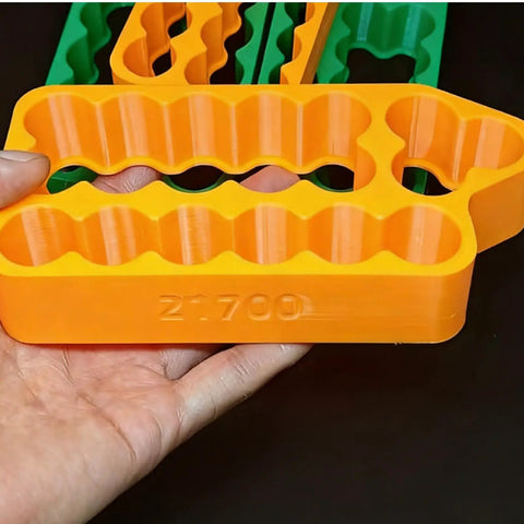 Slick Heavy Duty Spot Welding Jig For 18650 And 21700 Battery Packs Safe Insulated Cell Holder in orange, holding 21700 cells.