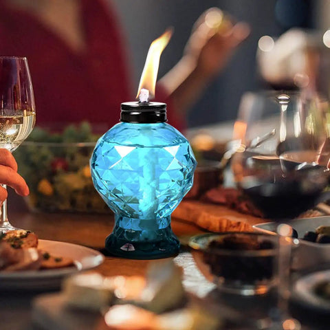 Blue diamond cut glass table top torch with flame, part of the Four Pack Glass Table Top Outdoor Torches With Citronella Refillable Glass Lanterns