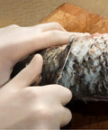 Top Notch Latex Disposable Gloves With Corn Starch Powdered Finish For Food Handling And Light Industrial Chores Smooth As Butter X Large being used to fillet a fish.