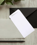 Thick White Blank Letter Envelopes 230x120mm Bulk Pack of 100 Durable Paper with black envelope on marble