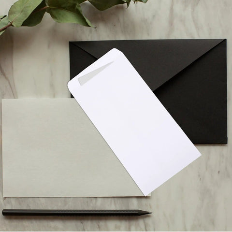 Thick White Blank Letter Envelopes 230x120mm Bulk Pack of 100 Durable Paper with black envelope on marble