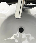 4 Pcs Silicone Bathtub Stopper White Flat Cover Universal Drain Plug beside a shiny chrome faucet above a white sink.