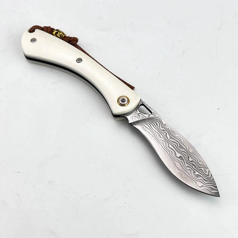 Folding Pocket Knife With 2.99 Inch Damascus Steel Blade And Ivory Synthetic Handle shown closed on white background