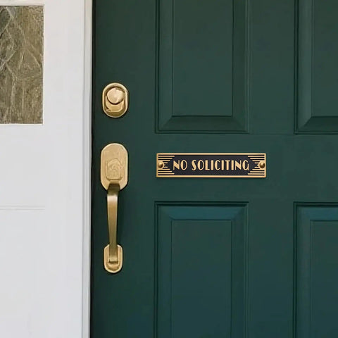 Brass No Soliciting Sign Six Point Five Inch Classic Art Deco Style With Brushed Matte Finish on green front door.