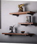 Rock Solid Heavy Duty Wall Mounted Shelf Brackets Four Pack Black Iron Pipe Style with wooden shelves displaying decor.