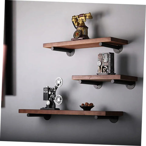 Rock Solid Heavy Duty Wall Mounted Shelf Brackets Four Pack Black Iron Pipe Style with wooden shelves displaying decor.