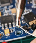 Leaded Solder Wire 0.6mm Sn63Pb37 With Flux Rosin Core For Electronics Soldering 100g Roll in use on circuit board close-up