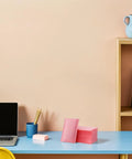 Pink Bubble Padded Mailers Self Seal Envelopes 100 Pack on blue desk with laptop and stationery