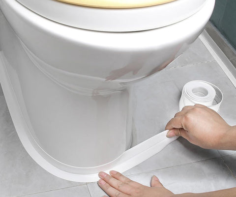 Applying the Waterproof Self Adhesive Caulking Tape For Bathrooms And Kitchens Peel And Stick Sealant Strip around a toilet base.