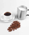 Milk Frothing Pitcher 12oz And 20oz Stainless Steel Jug For Espresso Machines And Latte Art beside a coffee cup and beans