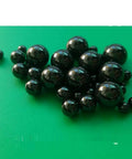Twenty Piece Lot Of 1.588Mm Silicon Nitride Ceramic Balls G5 Grade on a green background, showcasing various sizes of black ceramic balls.