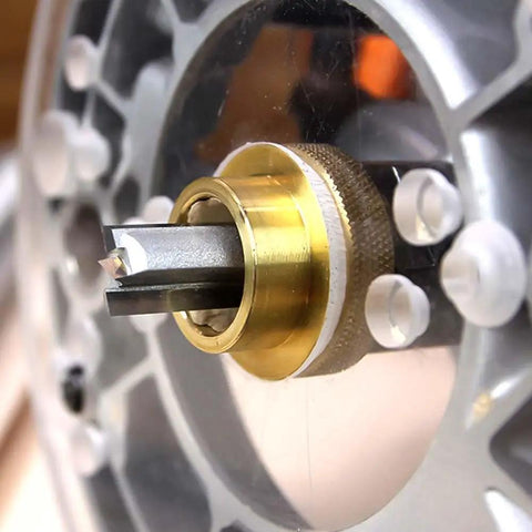 Close-up of Top Shelf 5/16 Inch Brass Router Template Guide With Dead On Lock Nut Grip on router for precise woodworking cuts.