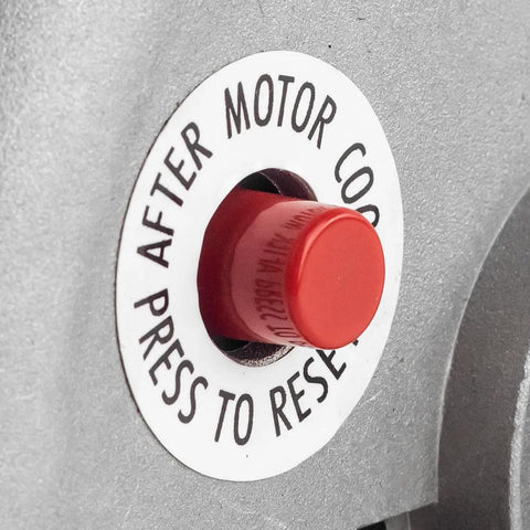 Air compressor motor red reset push-button on metal housing.