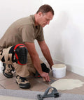 Man wearing Knee Pads For Work With Soft Gel Core And EVA Foam Padding, Ergonomic Cushion, applying tile adhesive on floor