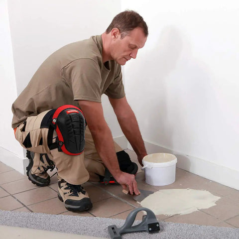 Man wearing Knee Pads For Work With Soft Gel Core And EVA Foam Padding, Ergonomic Cushion, applying tile adhesive on floor