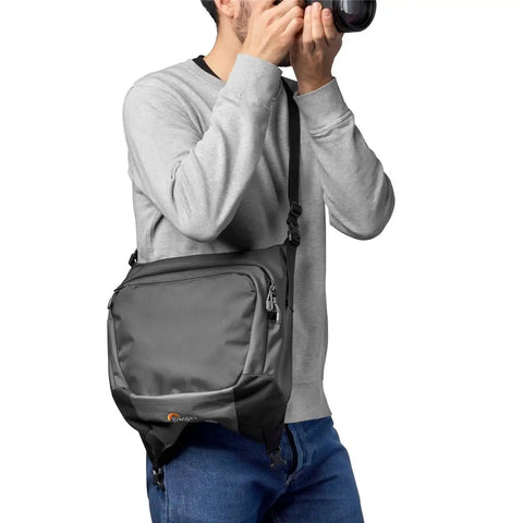 Photographer using Pro Trekker BP 550 AW II Backpack for Pro Photogs and On The Go Travelers, Modular Gear System Converts to Two Carry On Bags, MaxFit Design Carries More Gear, Removable Waist Belt, Stowable Tripod Straps, Black.