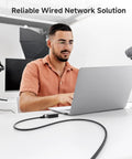 Man using laptop connected with Snagless Cat 6 Ethernet Cable 20ft High Speed Network Cord For Gaming PCs Routers And More