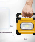 Heavy Duty 60W LED Work Light 15000 Lumens Rechargeable Waterproof Floodlamp held with dimensions for size comparison.