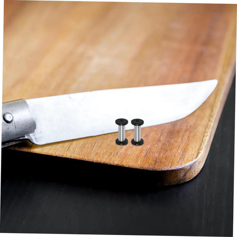 Boss Grade Stainless Steel Knife Handle Screws With Locking Spindle Pins Two Pack on wooden cutting board next to knife.