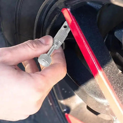 Hand using Aircraft Tire Valve Stem Removal Tool With Pro Grade Safe Core For Standard Bore Valves on aircraft tire rim