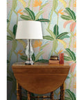 Tropical Botanical Vinyl Wallpaper Featuring Subtle Leather Texture Built Different Heavy Duty Commercial Grade Finish Custom Printed Paste Required with lamp and wooden table.