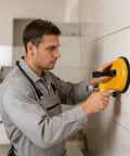 Worker using Adjustable Vacuum Suction Seam Clamp For Floor Gap Fixing And Tile Alignment, Pro Grade Heavy Duty Rubber Cups on wall tiles