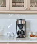 Heat N Brew 10 Cup Programmable Coffee Maker with Stainless Steel Finish on kitchen counter, ideal for home cafe.