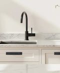 4 Pack Black Zinc Alloy Barn Door Handles Set installed on white kitchen cabinets below black faucet.