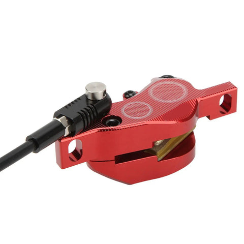 Rock Solid Four Piston Hydraulic Disc Brake Set For Mountain Bikers With Drop Dead Smooth Bilateral Oil Lines And Tough Resin Pads For Hardtail Or Full Suspension Shredding, close-up view of red brake caliper with hydraulic line.