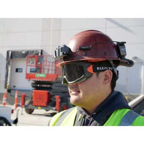 Worker wearing tinted safety goggles with anti-fog lens for pro grade eye protection, scratch resistant UV shield, adjustable vents, ANSI Z87.1 Plus.