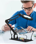 Man using Six Piece Welding Fixture With Magnifying Glass Lamp Clamp And Circuit Board Holder For Soldering, Durable Iron Build.