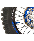 Tusk rim lock nut/spacer kit blue mounted on dirt bike front wheel with disc brake rotor