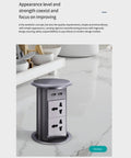 Slick Auto Rising Desk Power Strip With Fast Wireless Charger Tempered Glass Top Hidden Flush Mount Socket Multi Port Outlet in kitchen setting.