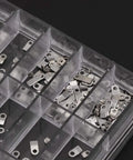 Assorted steel adapters and screws in a box from 12 Size Casing Clamp And Screw Set For Watch Repair Kit