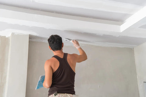Person using a Stiff One And A Quarter Inch Putty Knife For Light Duty Construction And Home Projects Carbon Steel Blade For Easy Spreading And Cleanup