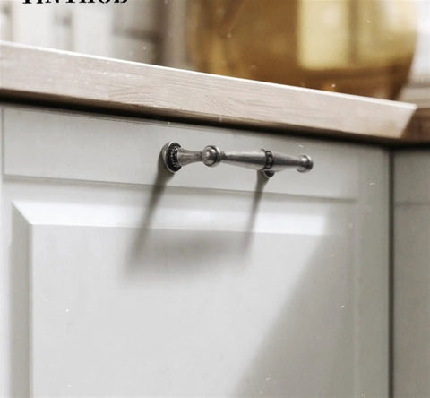 Vintage Antique Bronze Cabinet Handles And Drawer Pulls For Kitchen Cupboards in retro style on light cabinet door.