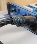 10 Ft Flexible Vacuum Hose Dust Collection Kit connected to woodworking tool's dust port on a miter saw in a shop.
